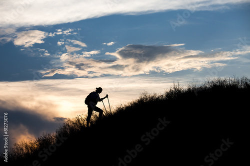 Female hiker silhouette with massive clouds
