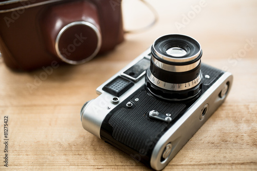 Macro photo of retro manual camera and leather case on table