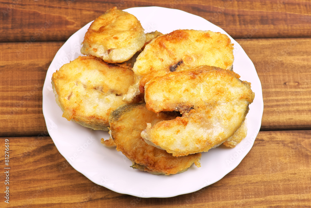 Cooked, fried pieces of fish on a white plate Cooked, fried pieces of fish on a white plate