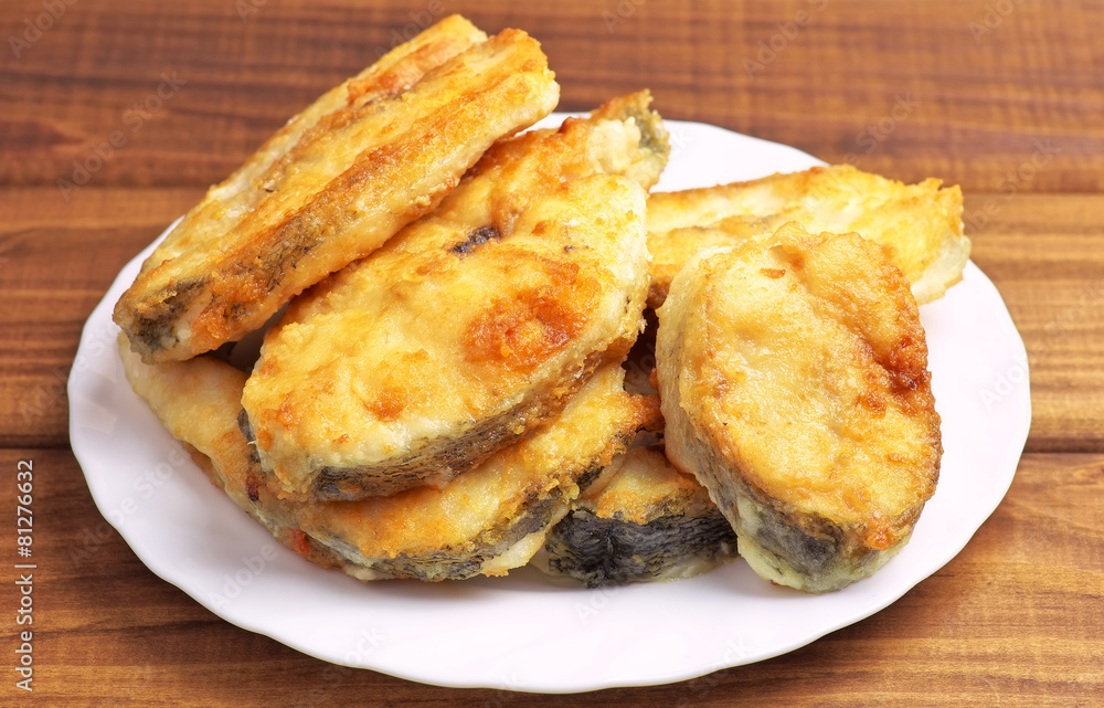 Cooked, fried pieces of fish on a white plate Cooked, fried pieces of fish on a white plate