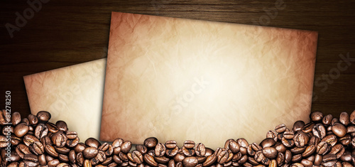 coffee beans and paper old on a wooden table. Dark background © Tabthipwatthana