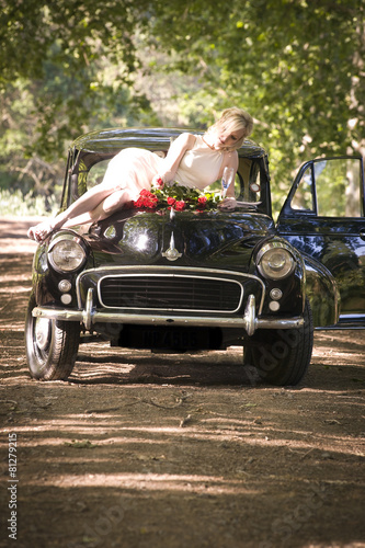 Young couple stopped on side of dirt road with vintage car