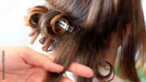 Hair stylist curling hair of future married woman