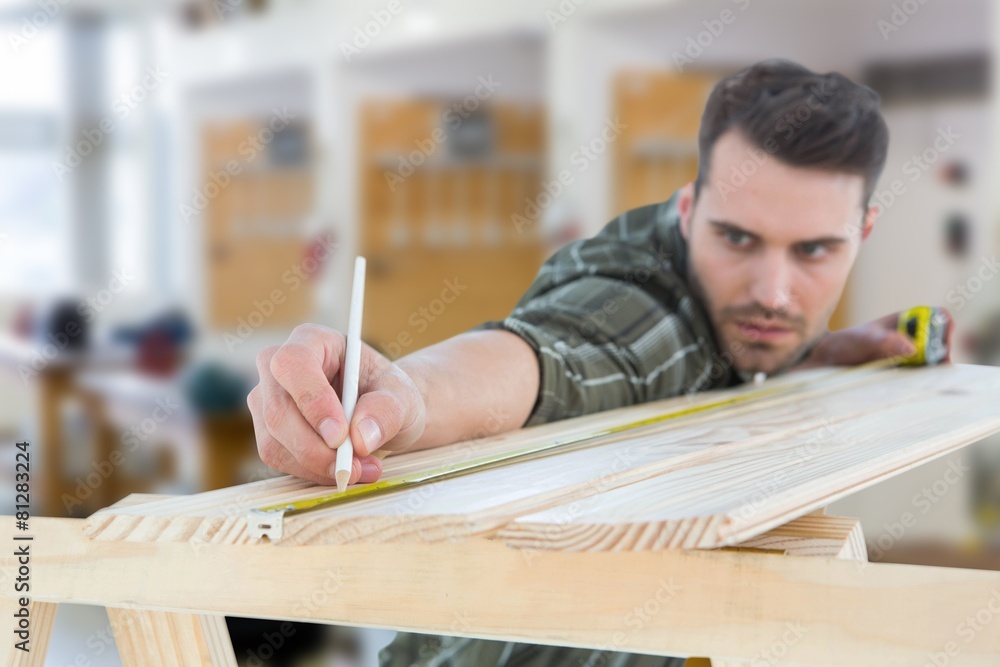Composite image of worker marking on wooden plank Composite image of worker marking on wooden plank