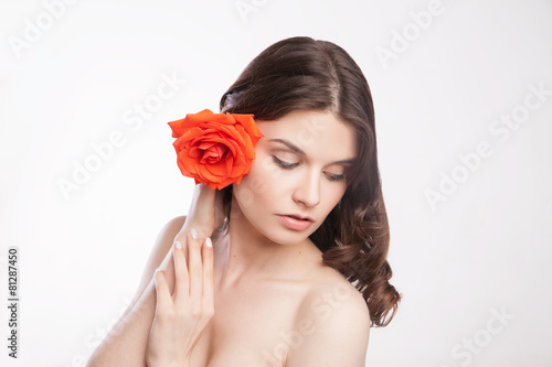 portrait of beautiful brunette woman with red rose
