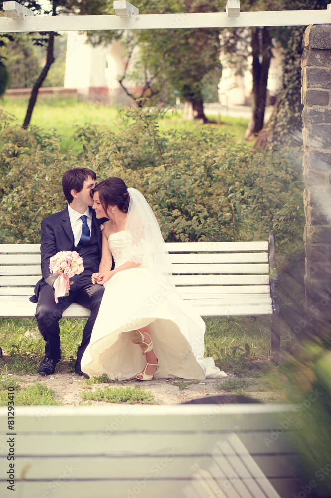 Bride and groom sitting on bench Bride and groom sitting on bench