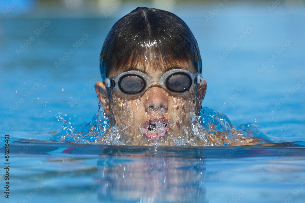 Fototapeta premium Child swimming in a pool