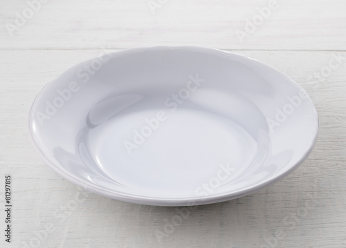 Empty white ceramic plate on wooden table