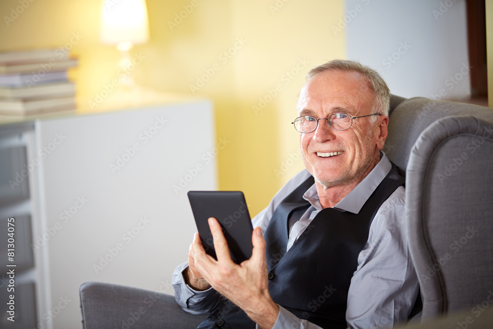 Senior man at home reading on a e-book 3 Senior man at home reading on a e-book 3