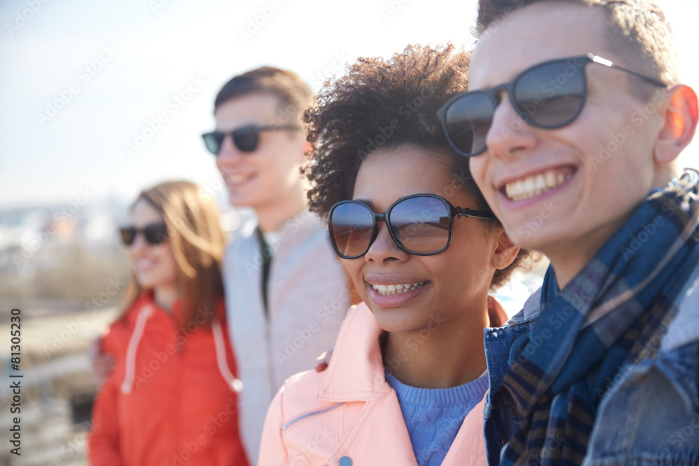 happy teenage friends in shades hugging on street happy teenage friends in shades hugging on street