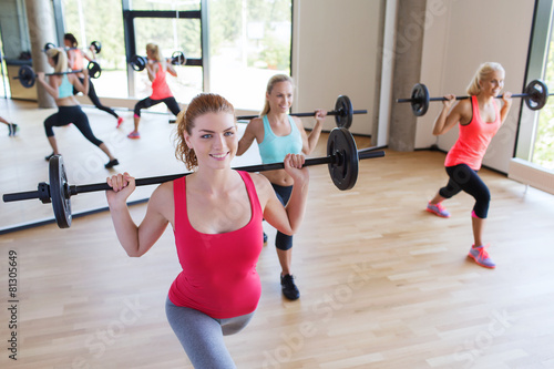 group of women excercising with bars in gym