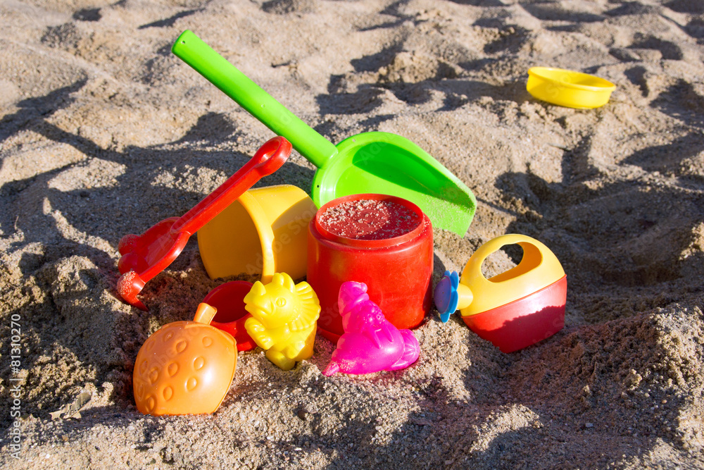 Sandspielzeug in einem Sandkasten Sandspielzeug in einem Sandkasten