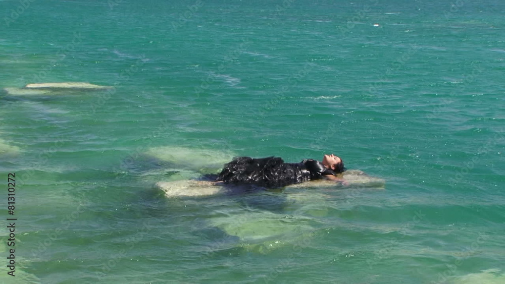 Woman In Black Laying On Cliff on the Lake Woman In Black Laying On Cliff on the Lake
