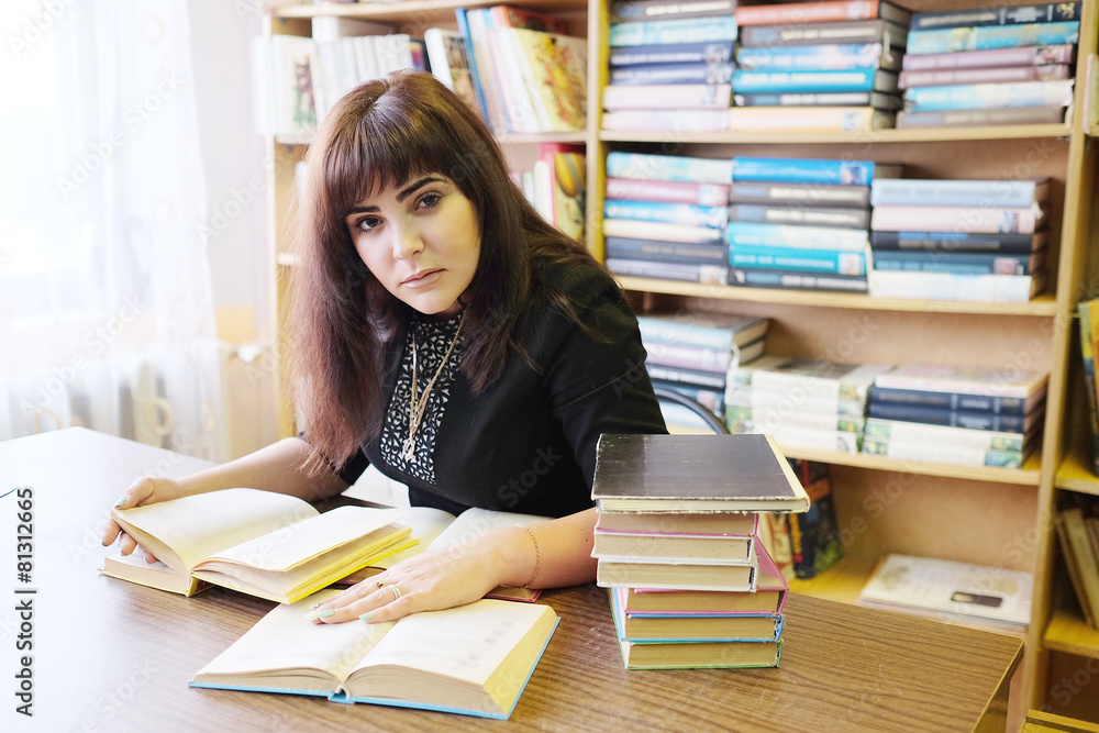 Female student reads the book in library. Female student reads the book in library.