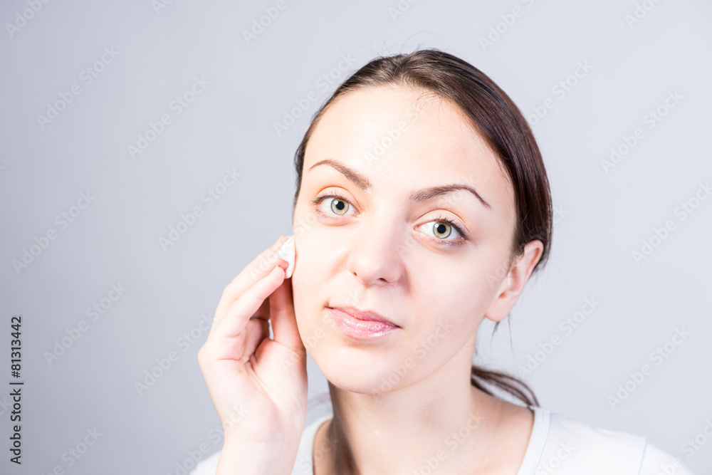 Girl Cleansing her Face Using Cotton with Cleanser Girl Cleansing her Face Using Cotton with Cleanser