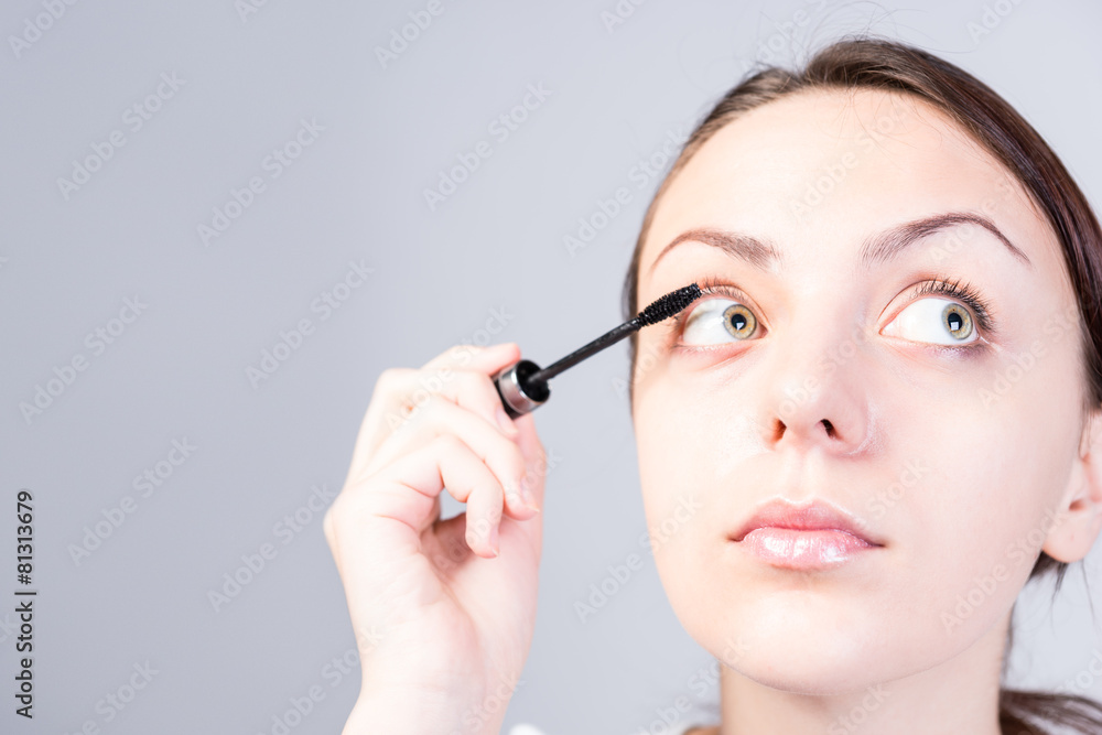 Woman Applying Mascara Makeup While Looking Right Woman Applying Mascara Makeup While Looking Right