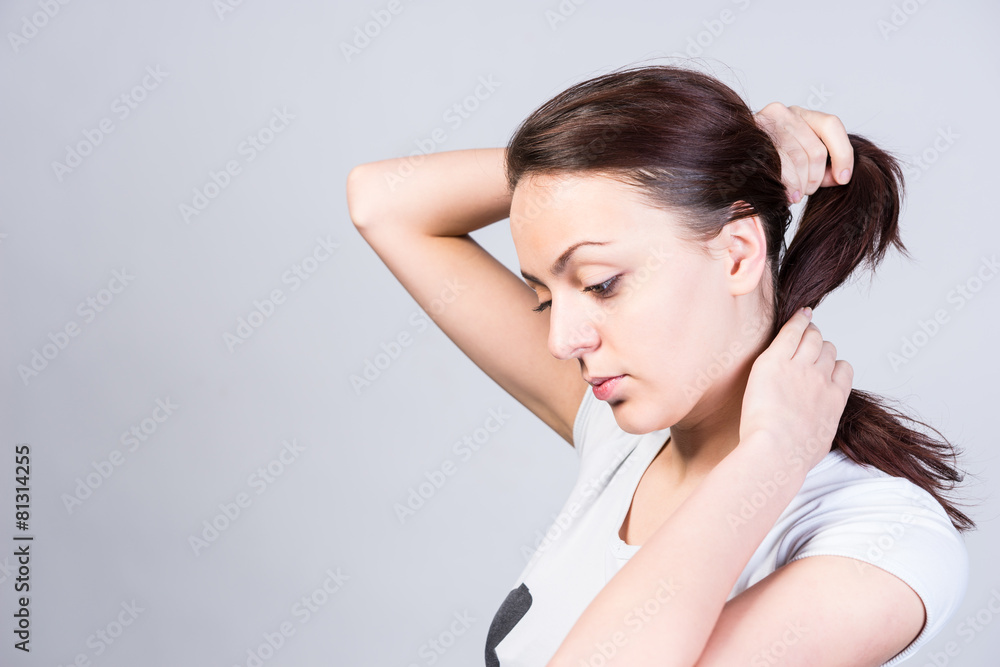 Young woman tying up her hair
