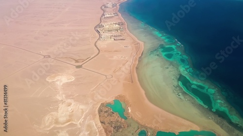 Aerial View from the Aircraft to Desert and Sea, sunny day