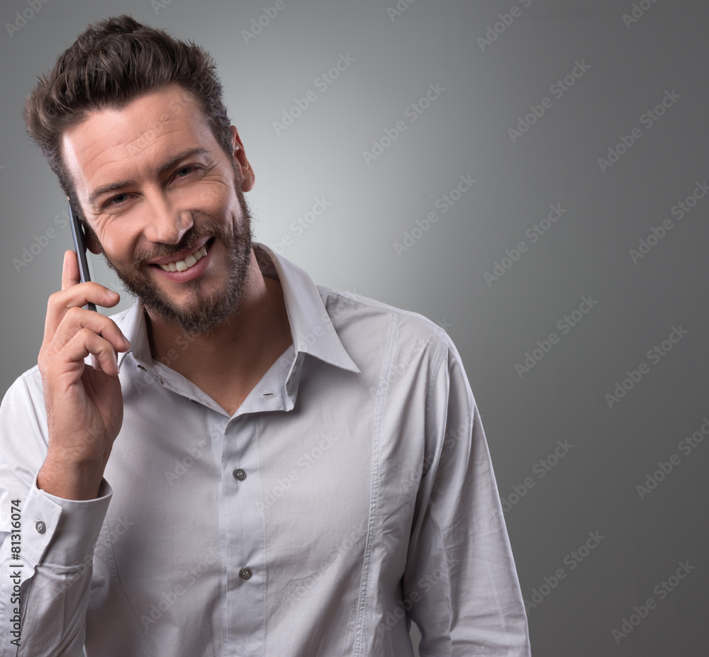 Smiling young businessman with smartphone