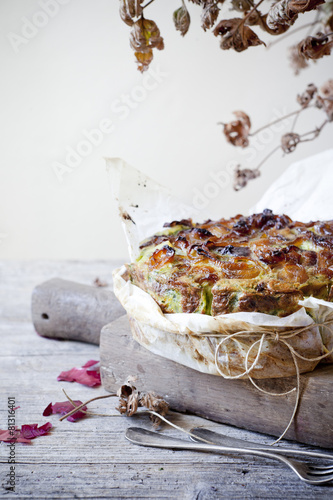 Obraz na plátně onions savoury cake on wooden cutting board with autumnal leaves