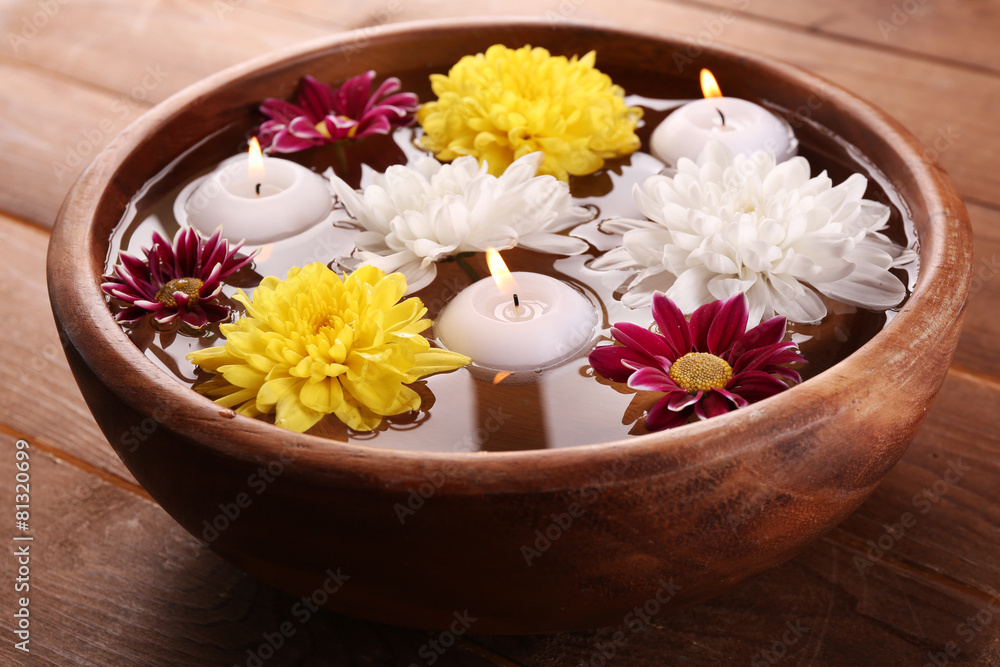 Bowl of spa water with flowers and candles Bowl of spa water with flowers and candles