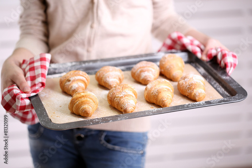 Croissant on pan in hands