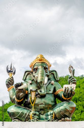 Green Ganesha Hindu God statue close up on natural background