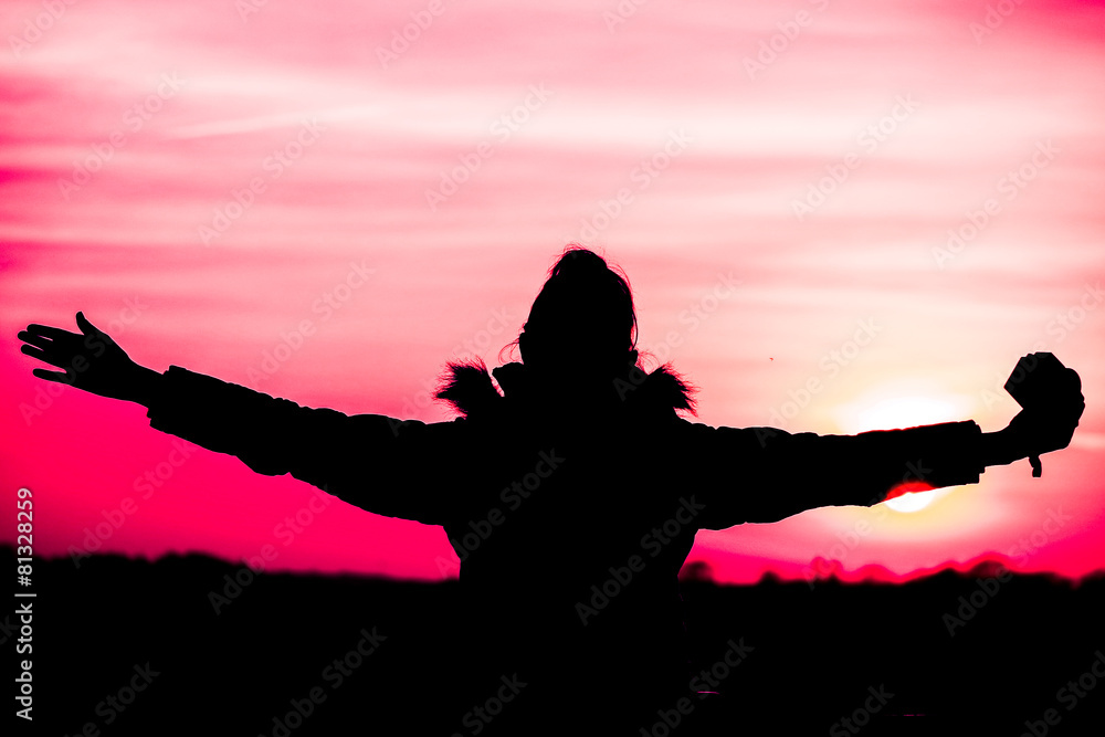 lady silhouette embracing sunset - background pink
