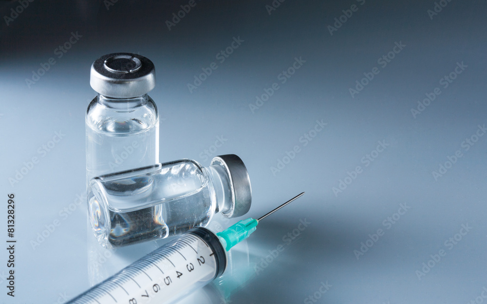 medical ampules and syringe on blue background medical ampules and syringe on blue background