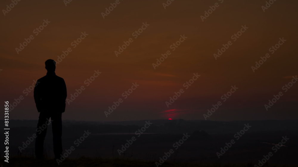 Man stands by sunset background on the top of the hill. Man stands by sunset background on the top of the hill.