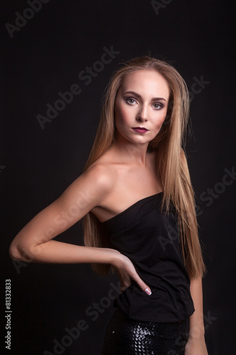 Beautiful woman in fashion clothes over black background