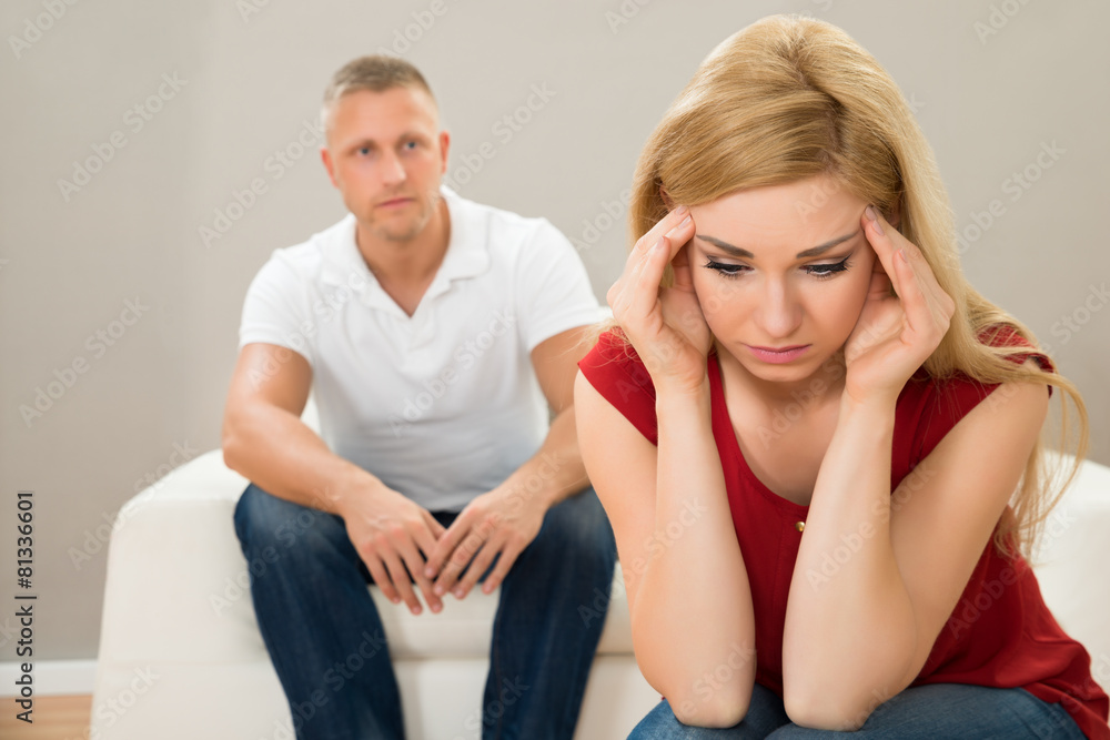 Man On Sofa Looking At Stressed Woman