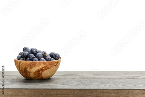 isabella grapes in wood bowl on table, border compostition photo