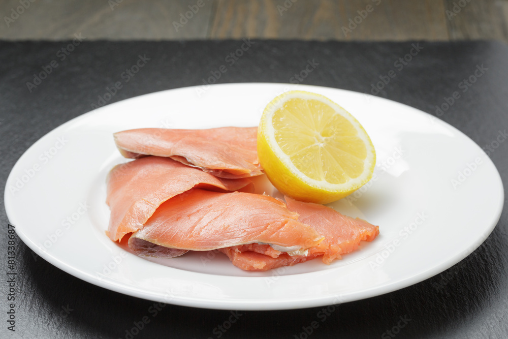 rolls of sliced smoked salmon on slate board