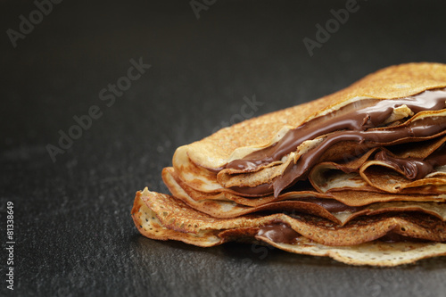 thin crepes or blinis with chocolate cream on slate