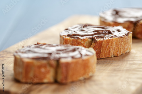 baguette slices with chocolate hazelnut spread on olive board