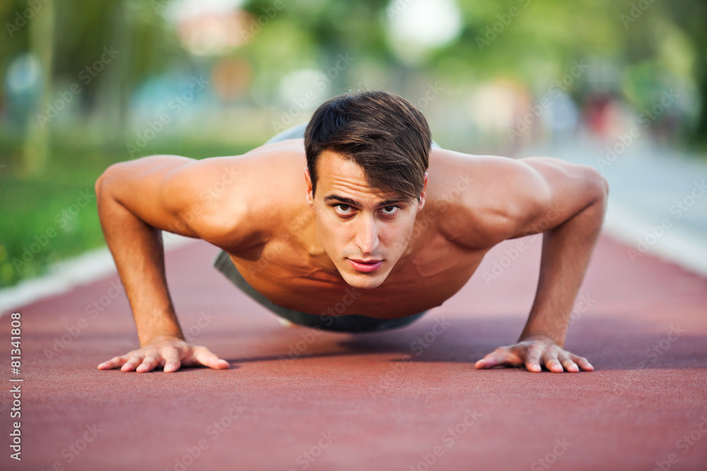 Young man exercising outdoor, doing push-ups Young man exercising outdoor, doing push-ups