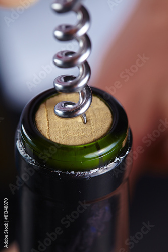 man opening a bottle of wine
