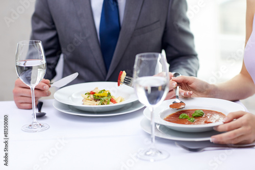 close up of couple eating appetizers at restaurant