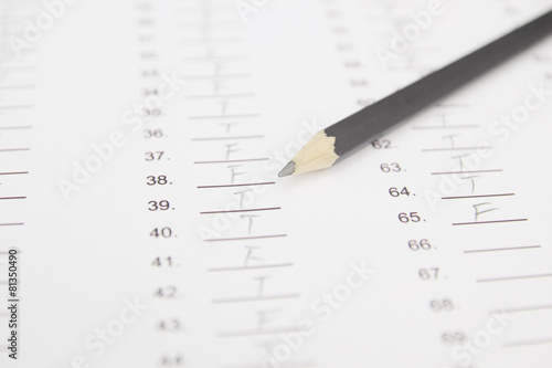 Standardized test form with answers bubbled in and a pencil, foc