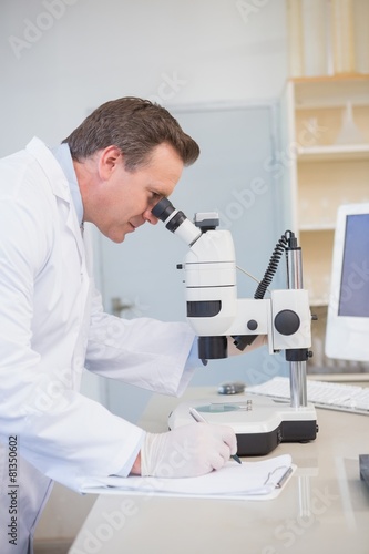 Scientist examining sample with microscope