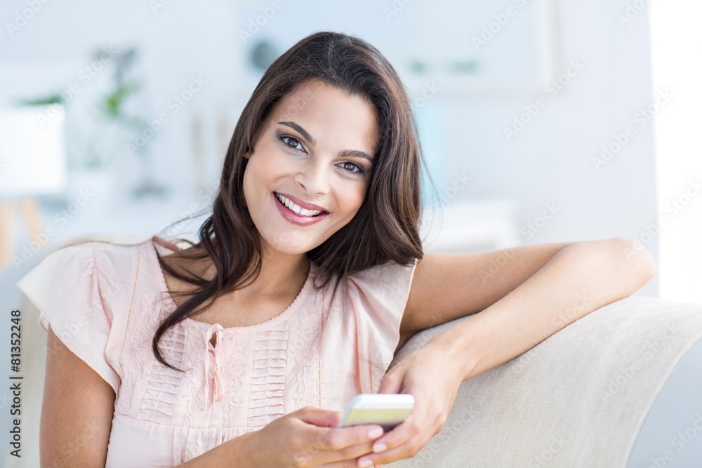Smiling beautiful brunette relaxing on the couch Smiling beautiful brunette relaxing on the couch