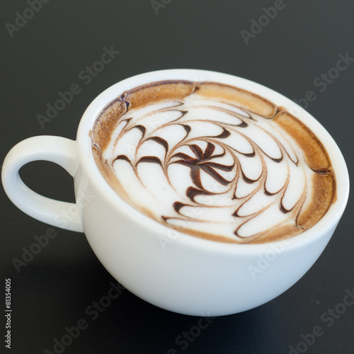 a cup of latte art on black background © joloei