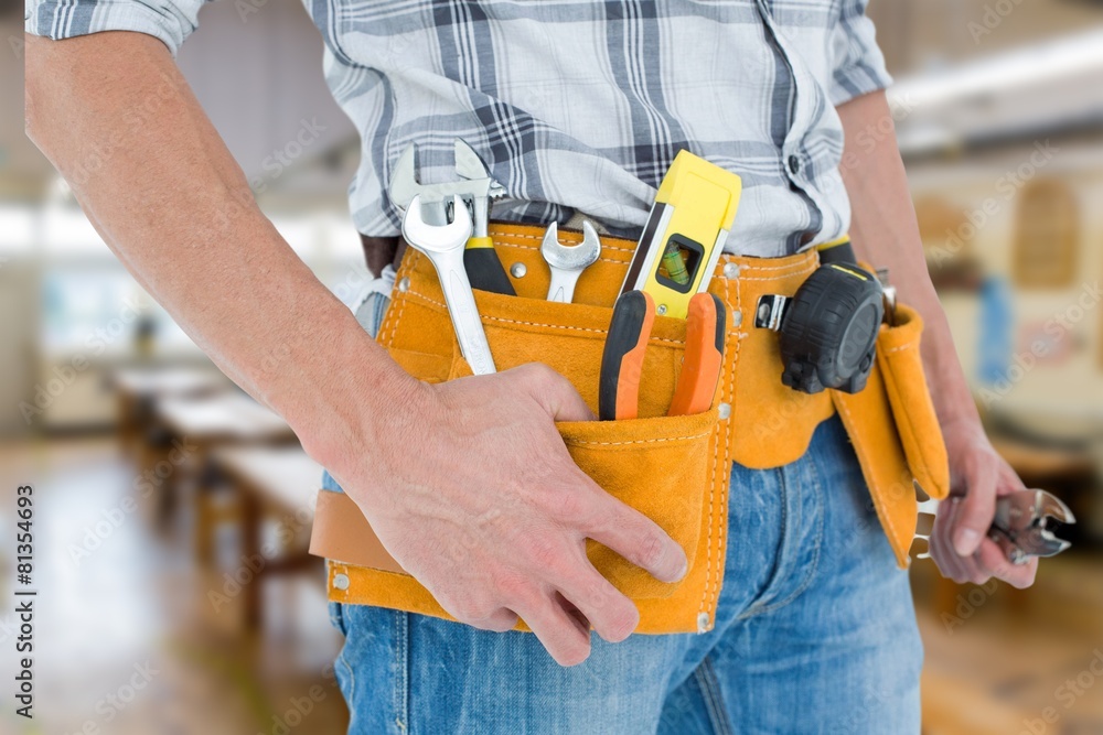 Cropped image of technician with tool belt Cropped image of technician with tool belt