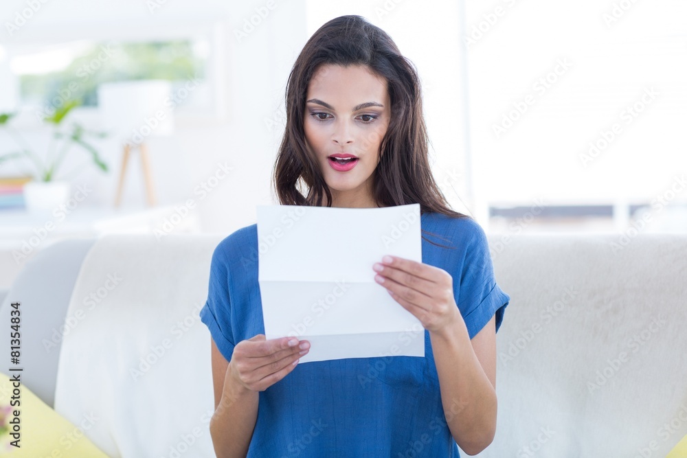 Surprised beautiful brunette reading letter Surprised beautiful brunette reading letter