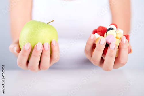 Woman holding apple and candies