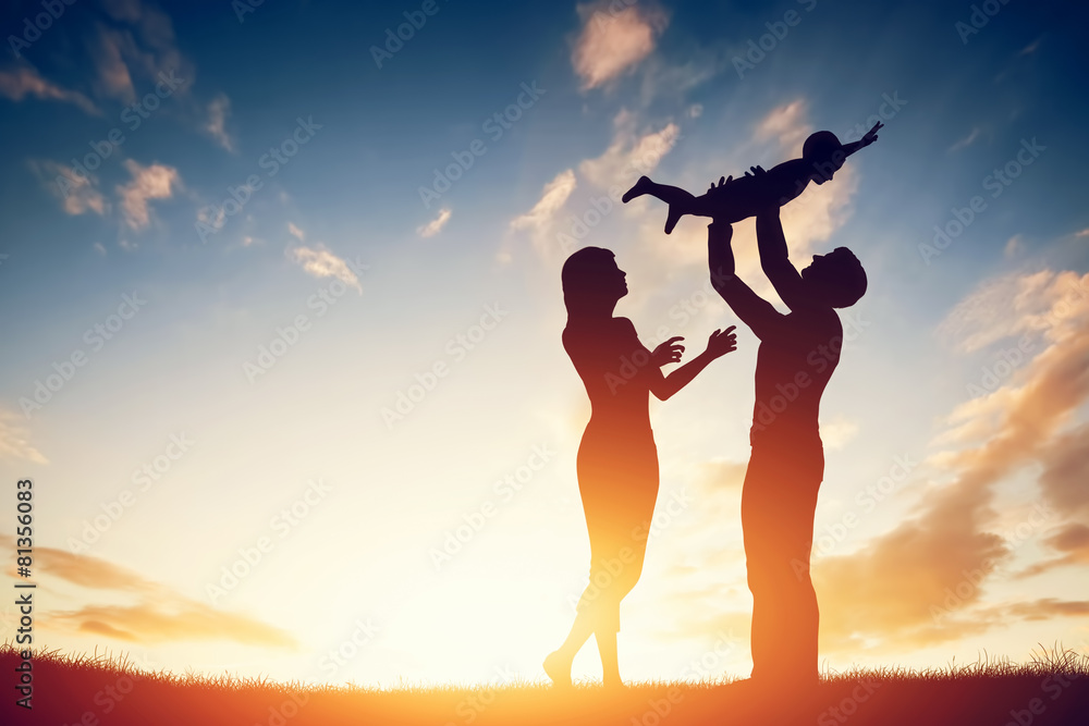 Happy family together, parents with their little baby at sunset - obrazy, fototapety, plakaty 