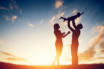 Happy family together, parents with their little baby at sunset