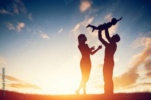 Happy family together, parents with their little baby at sunset photo