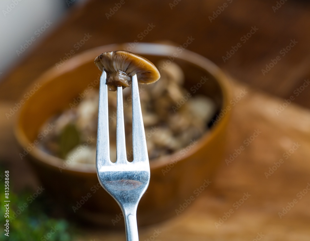 Fototapeta premium Marinated honey fungus in brown bowl on wooden table.
